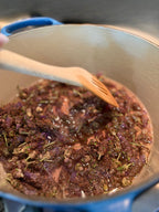 English lavender simmering in a Dutch oven, stirred with a wooden spoon